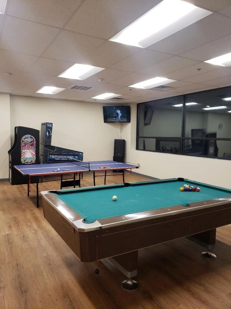 AUCC game lounge with pool table, ping-pong tables, and arcade machines